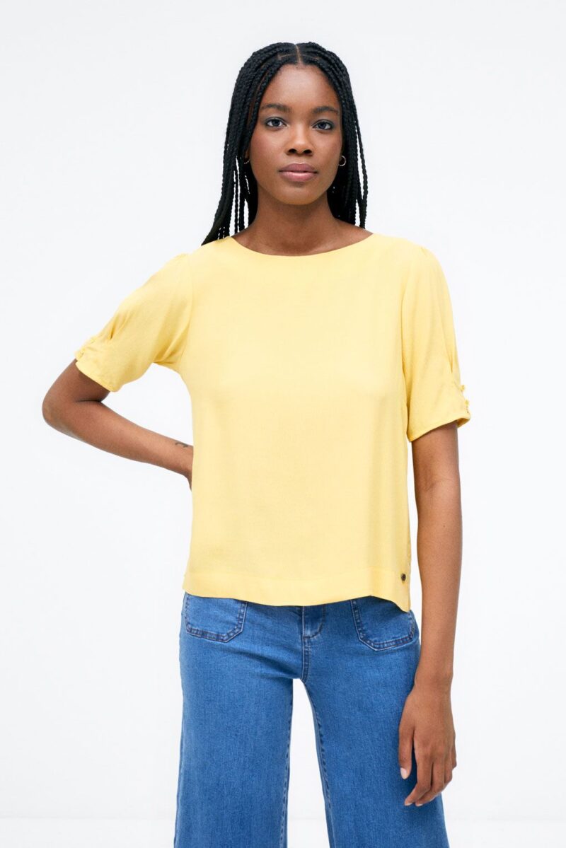 Blusa con botones en manga y abertura en espalda.
